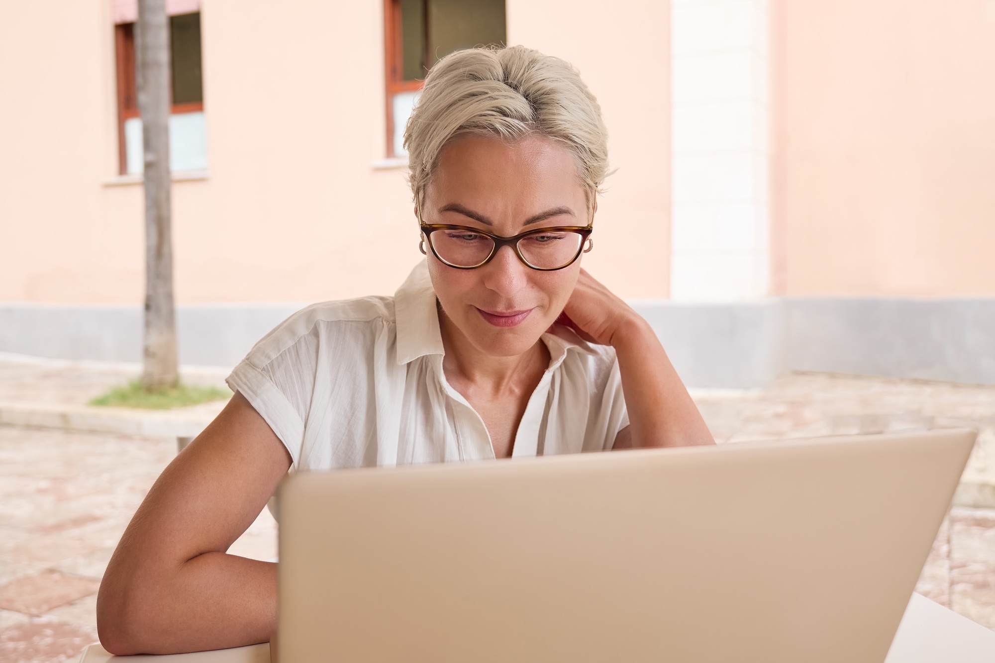 Female freelancer working on laptop at cafe.