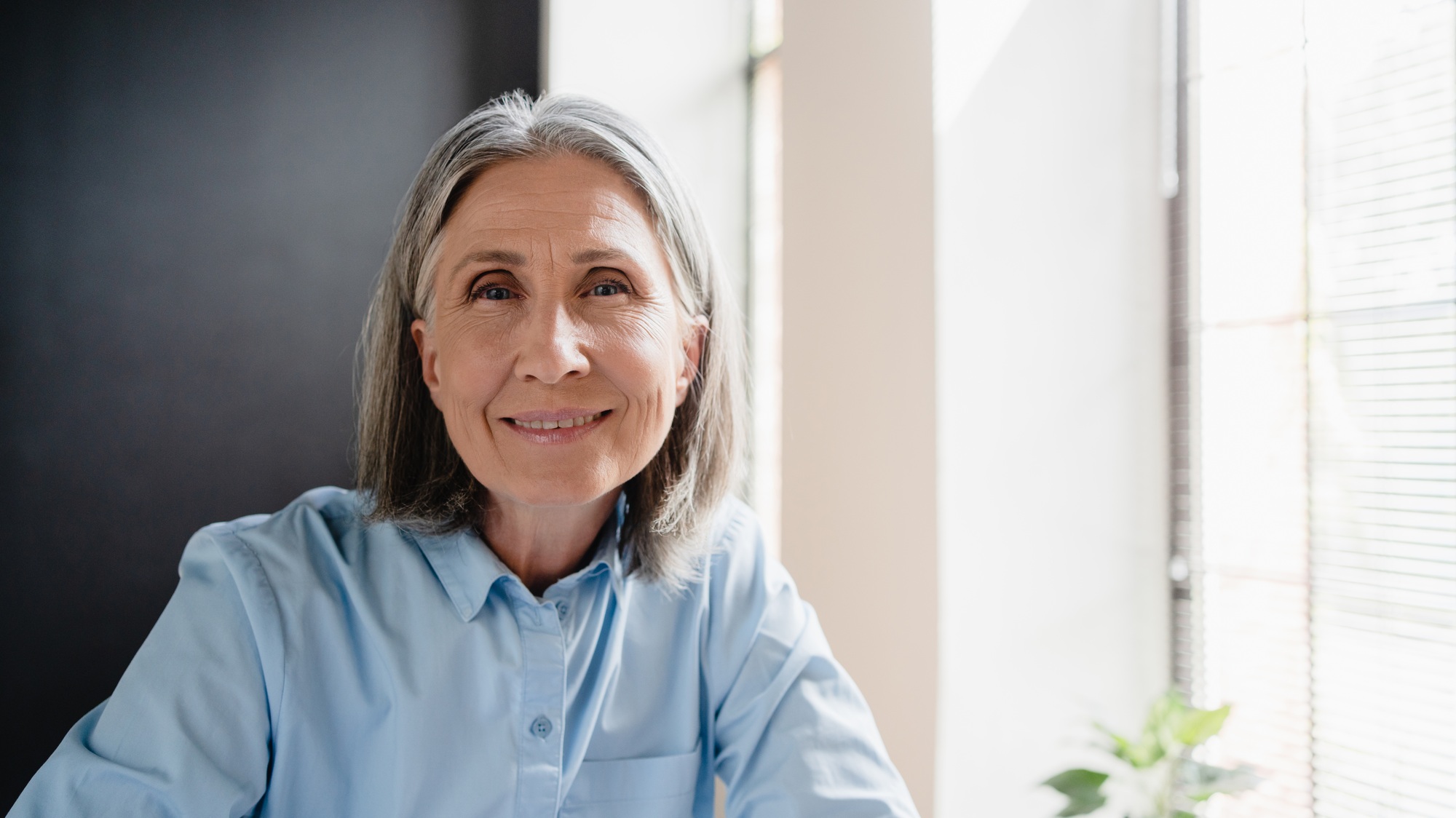 Happy mature elegant old lady professional businesswoman posing at home office.